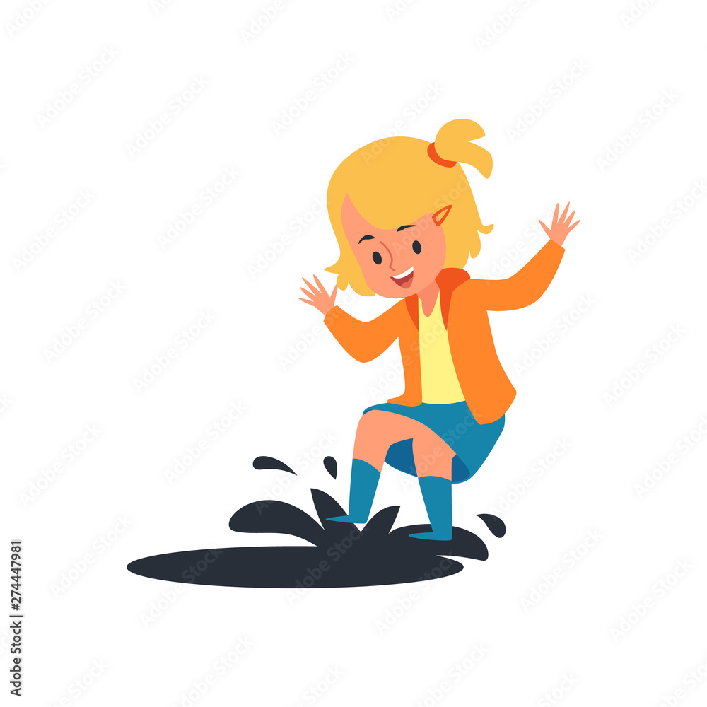 Happy child jumping on rain puddle, little blonde girl having fun splashing mud water