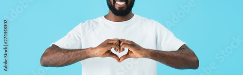 Tablou canvas cropped view of cheerful african american man showing heart sign isolated on blu