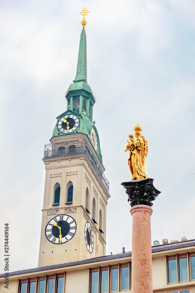 Obraz premium The Marian column (Mariensäule) and the steeple St. Peter's Church located on the Marienplatz in Munich. Bavaria, Germany