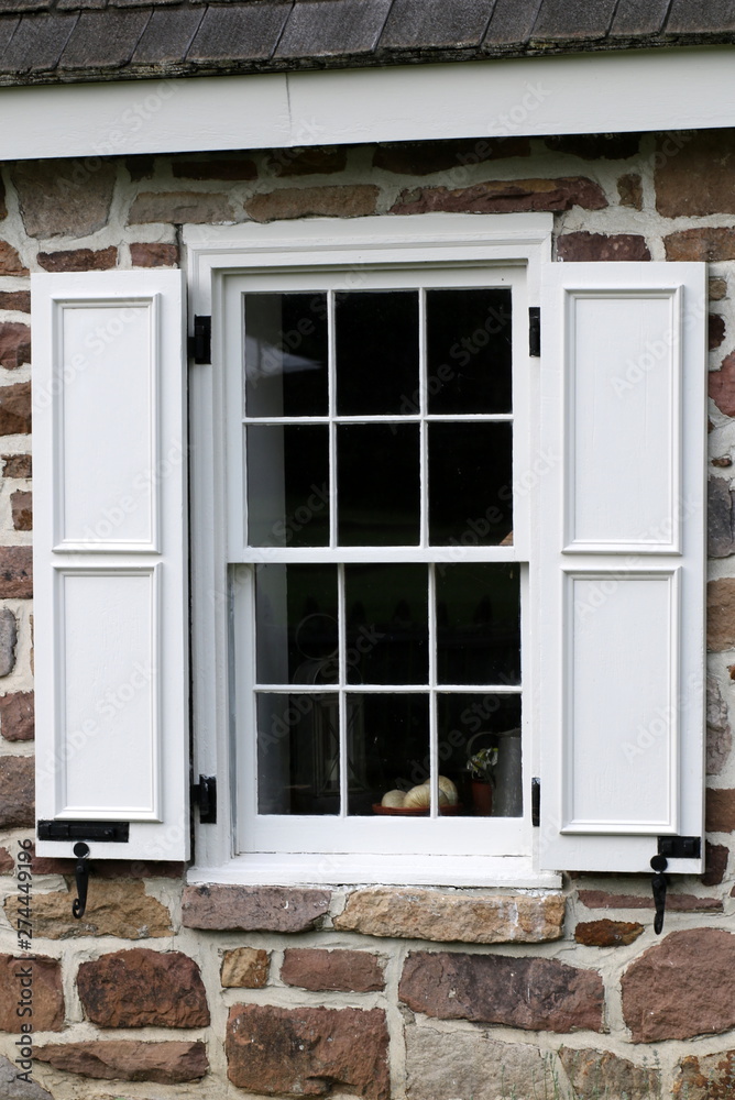 Fototapeta premium This window has bright white window shutters.