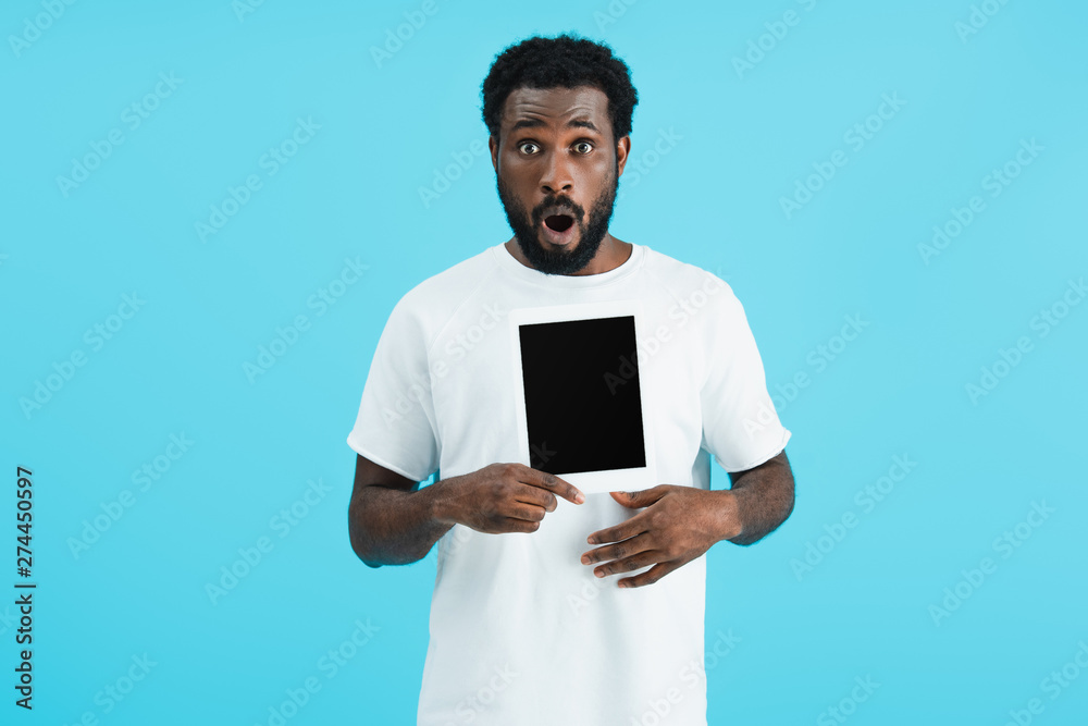 excited african american man showing digital tablet with blank screen isolated on blue excited african american man showing digital tablet with blank screen isolated on blue