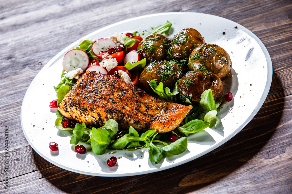 Grilled salmon, baked potatoes and vegetable salad Grilled salmon, baked potatoes and vegetable salad