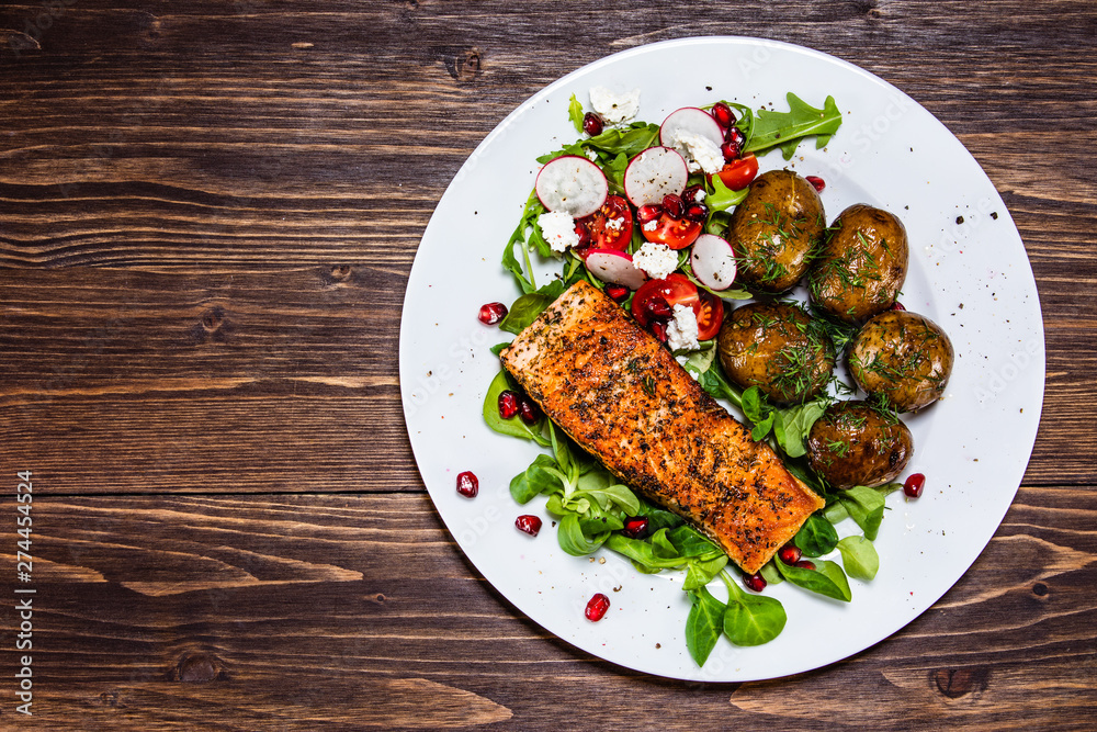 Grilled salmon, baked potatoes and vegetable salad Grilled salmon, baked potatoes and vegetable salad