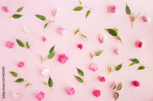 Flowers composition. Pattern made of pink roses flowers and green leaves on pink background. Flat lay, top view.