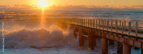 Yellow sun lights big storm waves. Sunset on the sea. Beautiful nature. photo