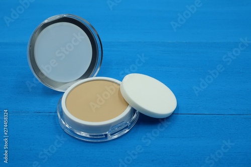makeup face foundation powder on blue wooden background