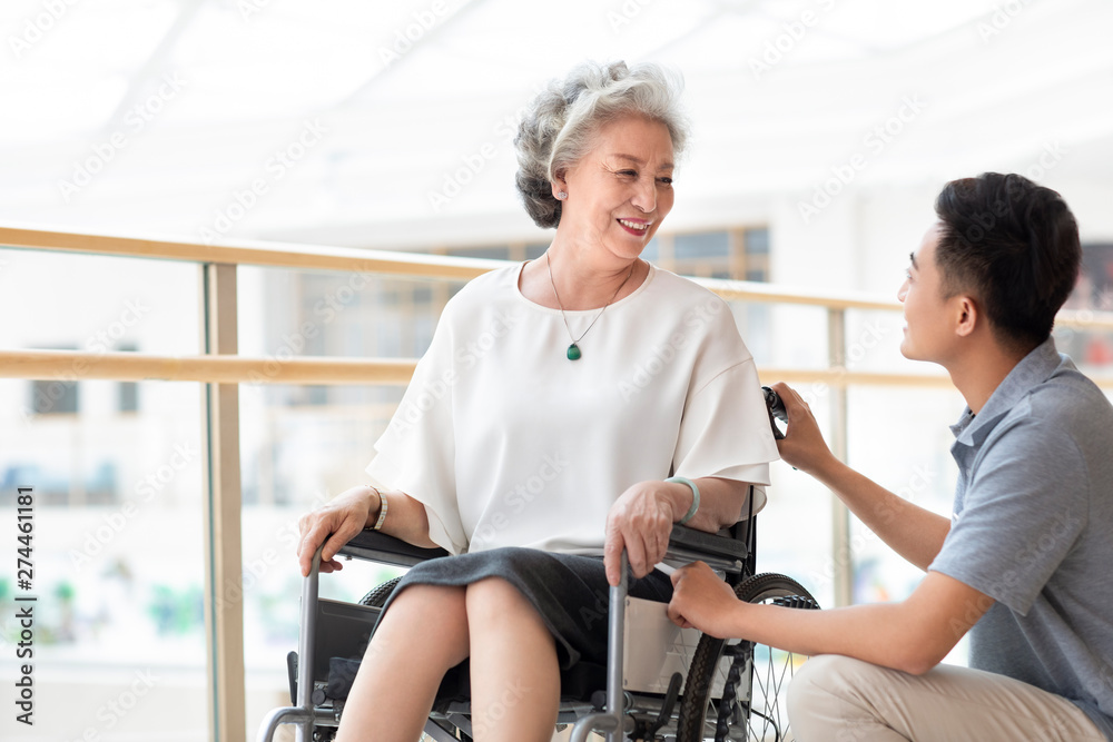 Nursing assistant taking care of senior woman in wheelchair Nursing assistant taking care of senior woman in wheelchair