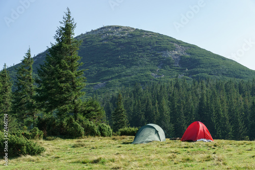 Summer landscape with camping tents on mountain valley.