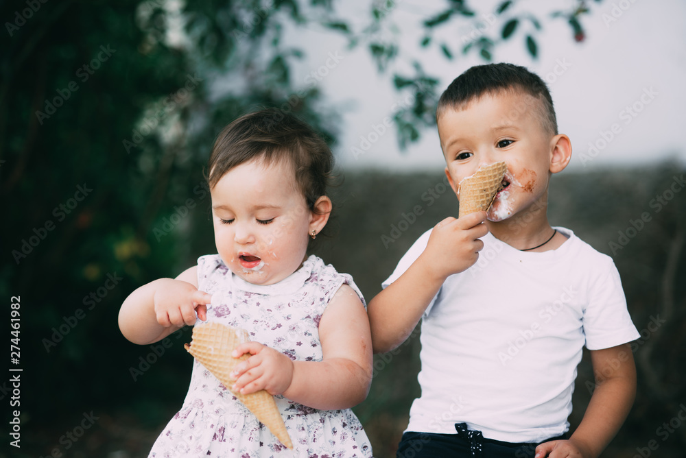 Cute kids Brother and sister are very cute outside in summer eating ice cream in the horn Cute kids Brother and sister are very cute outside in summer eating ice cream in the horn