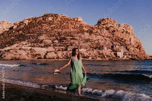 young beautiful woman walking by the beach at sunset. Relax and holidays concept