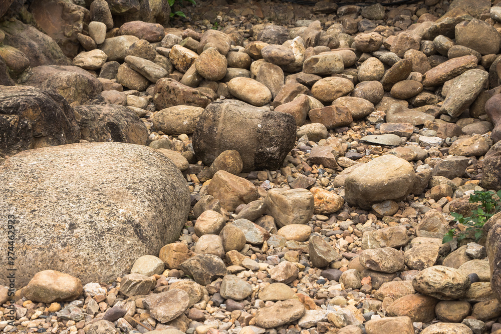 The thirsty riverbed revealed many pebbles. A disorderly heap of stones