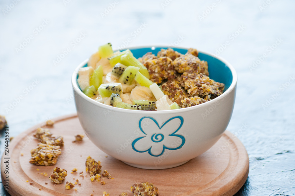 Healthy breakfast of granola, kiwi, banana and yogurt in a bowl on a wooden tray. Fitness diet for weight loss Healthy breakfast of granola, kiwi, banana and yogurt in a bowl on a wooden tray. Fitness diet for weight loss