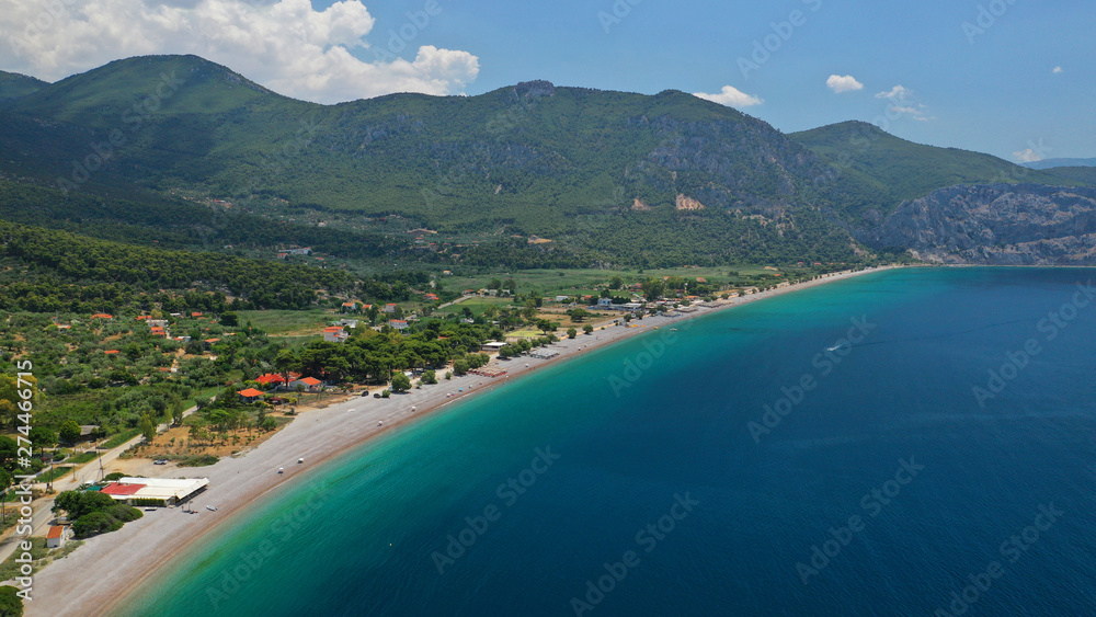 Aerial photo of tropical exotic island bay with beautiful emerald sea and deep blue cloudy sky