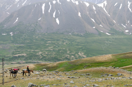 Western Mongolia mountainous landscape. Mongolian horseman and camel with tourists cargo. Altai Tavan Bogd National Park, Bayan-Ulgii Province, Mongolia. photo
