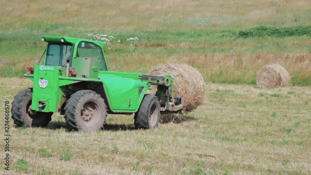 Tractor and haycocks. Tractor works on the field. Tractor and harvest. Tractor and haycocks. Tractor works on the field. Tractor and harvest.