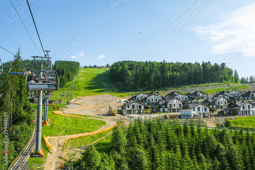 Editorial photo. Bukovel. Carpathians. Ukraine. June 15.2019. Construction of a tourist village of Bukovel on the mountain. Tourists on the ski lift in the summer.