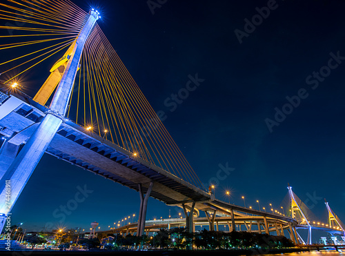 Night view of Bhumibol Bridge, also known as Ring road bridge, across Chao Phraya river with colorful light during coronation of King of Thailand on year 2019.