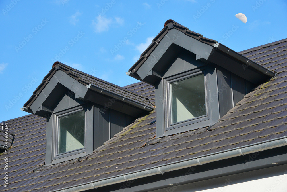 Dach mit Stehfalz-Metall verblendeten Sattelgauben und Schornstein