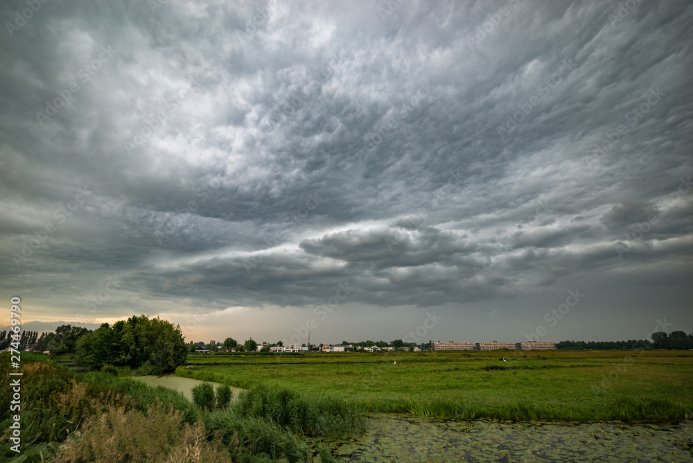 Obraz premium Storm cloud approaching over the dutch polder landscape between the cities of Gouda and Leiden, Holland