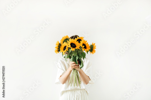 Young girl with sunflowers bouquet in hands on white background. Summer floral hero header composition.