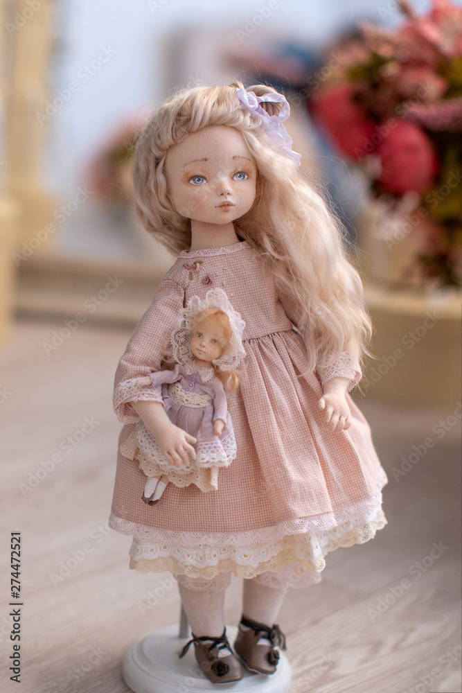 Fototapeta premium two dolls made by hands from textiles are very similar to living people. designer dolls. is on the stand. creating dolls for the new year holiday.