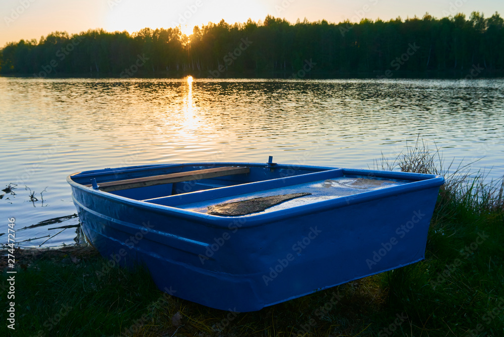 fishing boat in a calm lake water/old fishing boat/ wooden fishing boat in a still lake water fishing boat in a calm lake water/old fishing boat/ wooden fishing boat in a still lake water