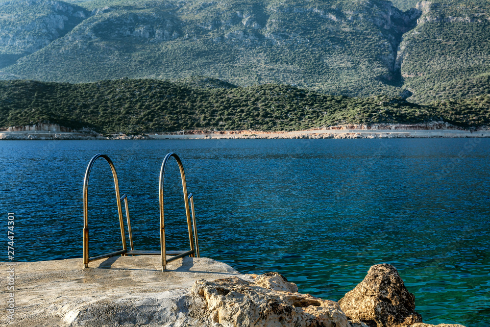 Stairway to the sea in a beautiful lagoon. A magical view of the sea and mountains. Calm and relax.
