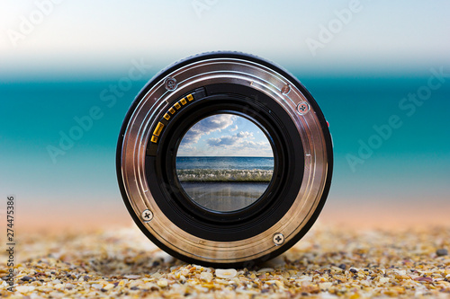 View of the sea surf through a photographic lens lying on a sandy beach on a sunny day. photo