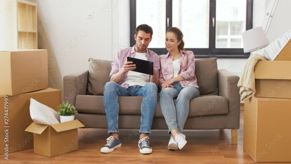 mortgage, accommodation and real estate concept - happy couple with tablet pc computer at empty room of new home mortgage, accommodation and real estate concept - happy couple with tablet pc computer at empty room of new home