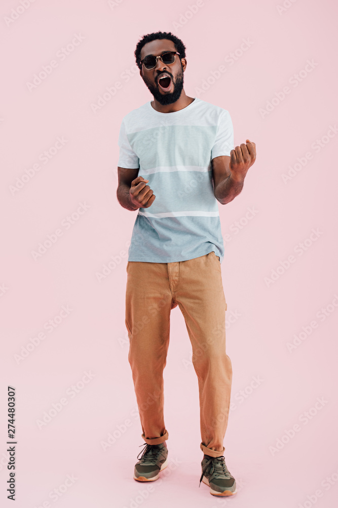 cheerful african american of man in sunglasses shouting isolated on pink
