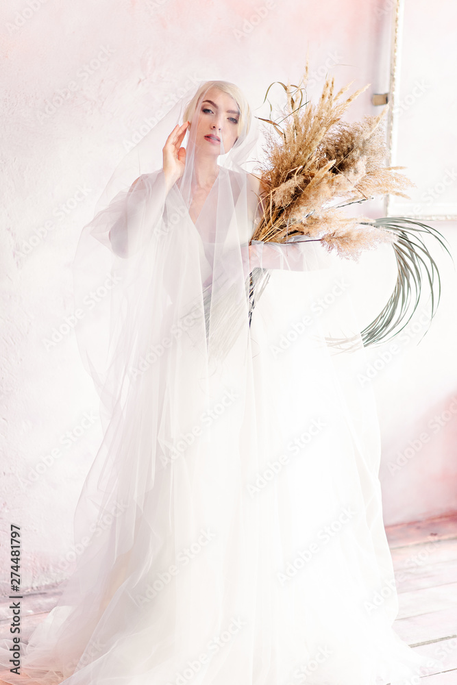 Fashionable and beautiful bride with a short haircut and an incredible smile. The image of the bride in the trend of this year.