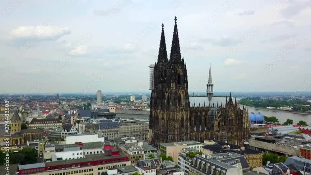 Aerial, reverse, drone shot, away from the German Cologne Cathedral, the Rein river and the Hohenzollern Bridge, in the background, on a sunny day, in Koln, Germany Aerial, reverse, drone shot, away from the German Cologne Cathedral, the Rein river and the Hohenzollern Bridge, in the background, on a sunny day, in Koln, Germany