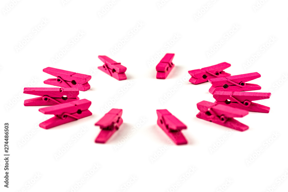 Fototapeta premium Pink wooden clothespins isolated on white background arranged in a circle
