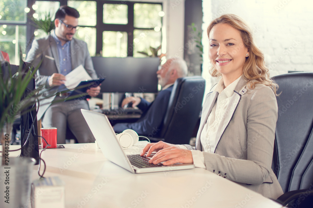Mid age businesswoman using laptop at her workplace Mid age businesswoman using laptop at her workplace