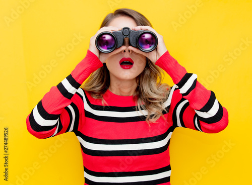 young woman in striped sweater with binocular photo