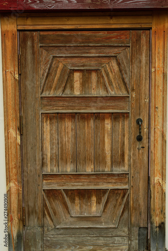 Old wooden brown door with metal handles. door in the street in the old house