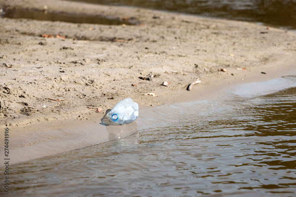 Obraz premium plastic trash bottle on beach. Pollution concept photo