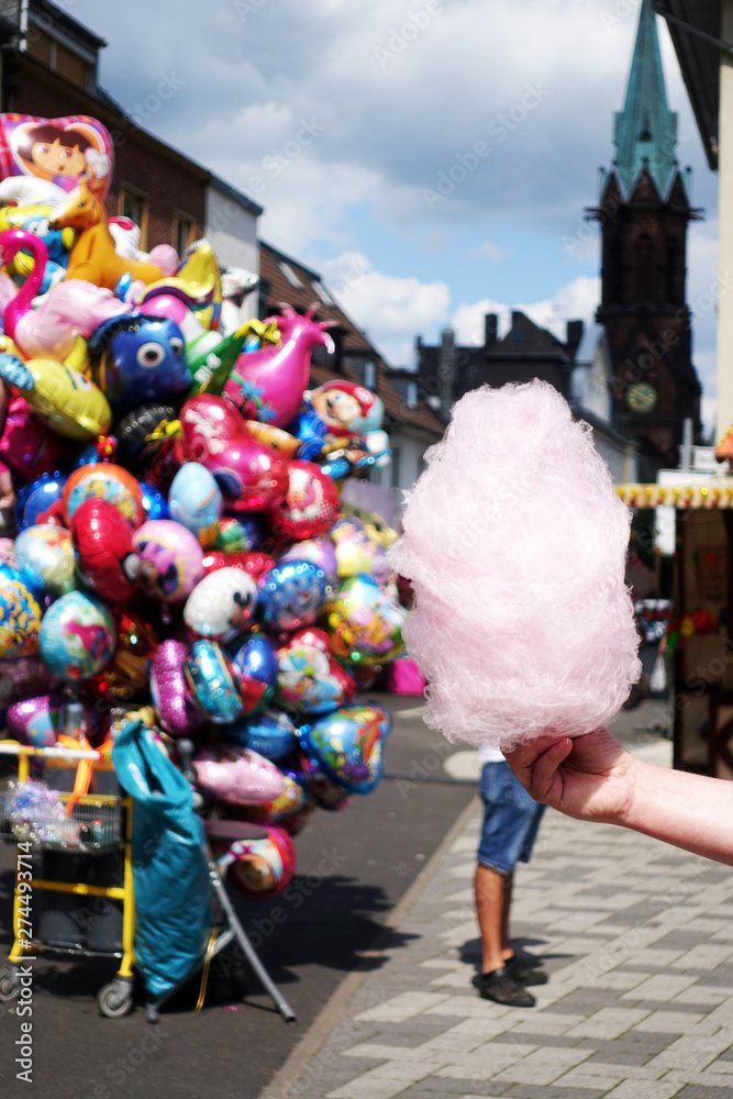 Obraz premium amusement park eating white cotton candy. enjoying a day at amusement park with fresh cotton candy in hand
