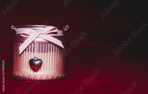 Perfumed candle in a pink jar with a bow and heart-shaped medallion