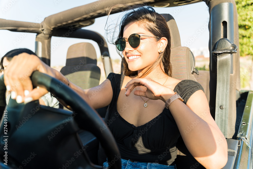 Happy Latin woman driving a 4x4 suv in the summer Happy Latin woman driving a 4x4 suv in the summer