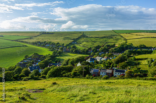 Canvas Print A view of a rural village (West Lulworth) from the hill under a majestic blue sk