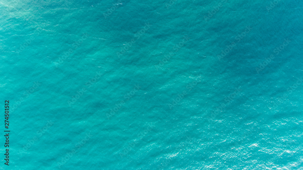 Ocean water texture. Aerial view of sea surface. Top view of transparent turquoise ocean water surface. Ocean water texture. Aerial view of sea surface. Top view of transparent turquoise ocean water surface.