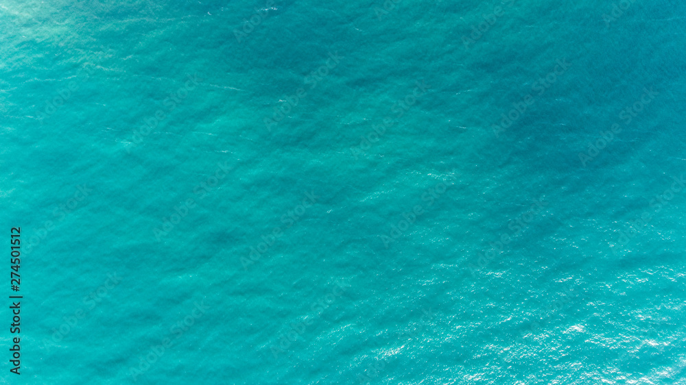 Ocean water texture. Aerial view of sea surface. Top view of transparent turquoise ocean water surface.