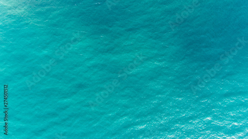 Ocean water texture. Aerial view of sea surface. Top view of transparent turquoise ocean water surface.