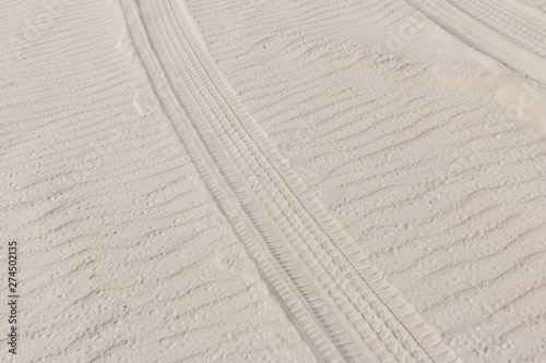 Fototapeta Naklejka Na Ścianę i Meble -  Tire trail in the sand of dunes on the beach or desert.