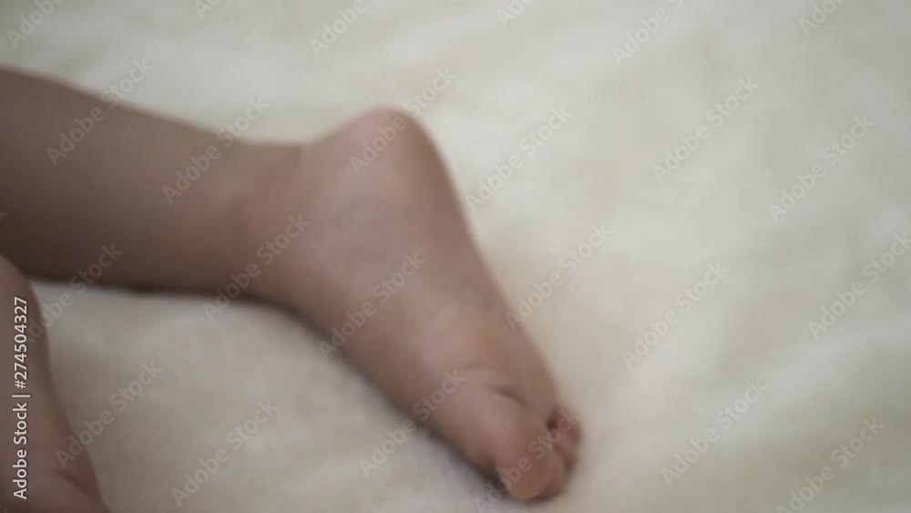 close up foot of sleeping kid moving a little bit. Concept of love family and parenthood relation close up foot of sleeping kid moving a little bit. Concept of love family and parenthood relation