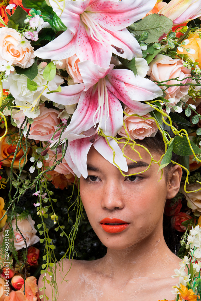 Naklejka premium Wreath of flowers background in Rose Red Pink fresh smell good Spring Summer for Beautiful Asian Woman portrait, Studio Lighting Campaign for Perfume, Cosmetic, Lipstick concept ads