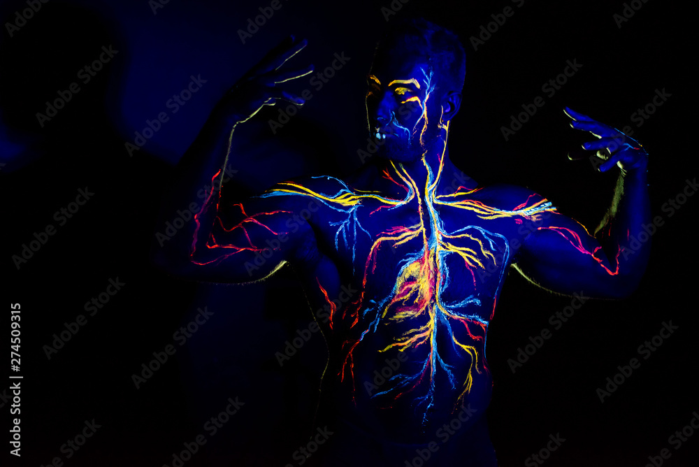 UV patterns body art of the circulatory system on a man's body. On the chest of a muscular athlete, veins and arteries are drawn with fluorescent dyes. The bodybuilder straightened the biceps UV patterns body art of the circulatory system on a man's body. On the chest of a muscular athlete, veins and arteries are drawn with fluorescent dyes. The bodybuilder straightened the biceps