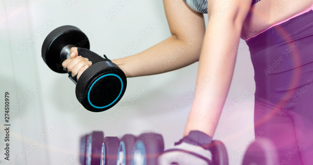 Concept of fitness.Woman exercising at the gym with dumbbell.Hands with dumbbells. Concept of fitness.Woman exercising at the gym with dumbbell.Hands with dumbbells.