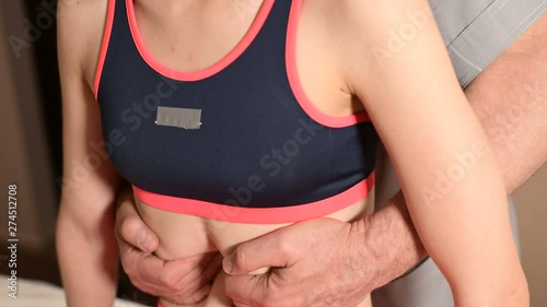 A male physiotherapist makes a visceral procedure of the abdomen and internal organs of a young girl patient. Alternative and non traditional medicine